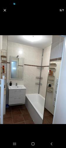 une salle de bain avec une baignoire blanche et un lavabo dans l'établissement Aquila, à Mâcon