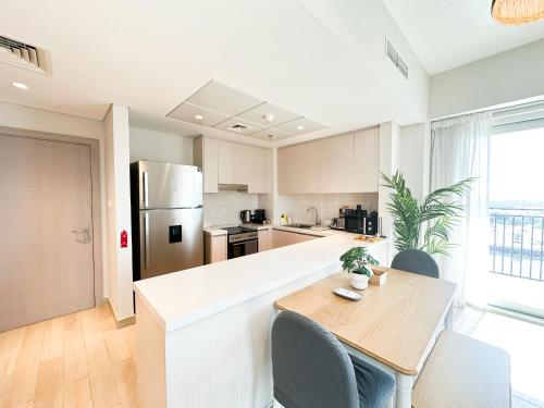a kitchen with a table and chairs and a refrigerator at 3BR Modern Getaway in Yas Island with Gym&Pool 609WE in Abu Dhabi