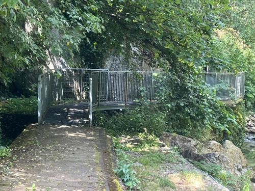 a wooden bench sitting under a tree next to a bridge at 18th Century Samnium Stone Residence in Alfedena