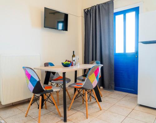 a dining room with a table with chairs and a blue door at Ven al Mar in Azolimnos