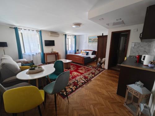 a living room with a table and yellow chairs at Beatrix Suites in Budva