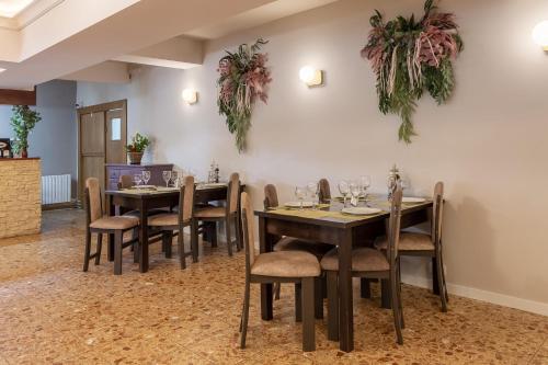 a dining room with tables and chairs and plants on the wall at Hotel Hera in Predeal