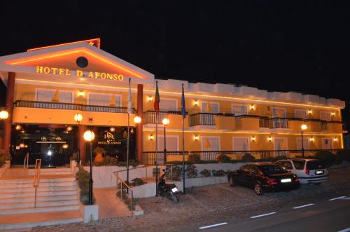 a hotel building with a car parked in front of it at D. Afonso Hotel & SPA in Monte Real
