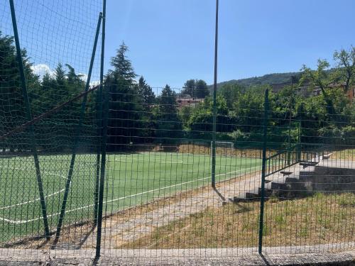 a tennis court seen through a fence at 18th Century Samnium Stone Residence in Alfedena