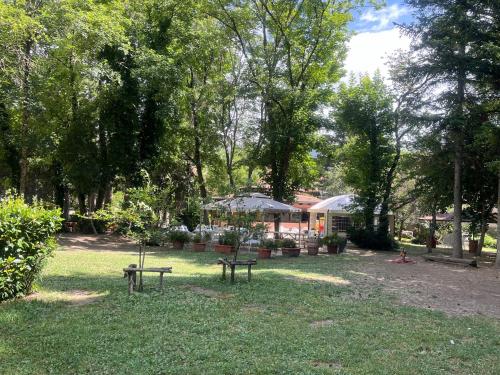 two benches in a park with trees and a building at 18th Century Samnium Stone Residence in Alfedena