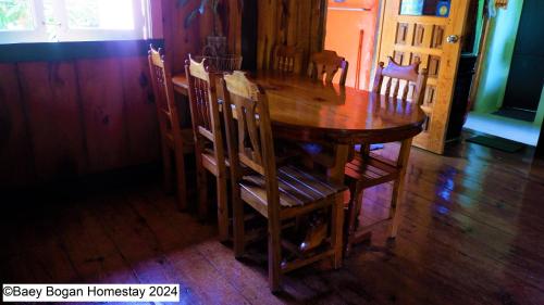 a wooden table and chairs in a room at Baey Bōgan Homestay in Sagada