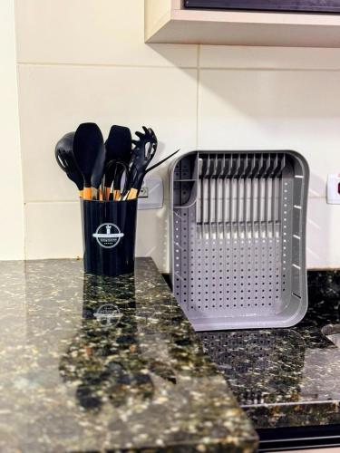a cup of utensils sitting on a kitchen counter at Apartamento Vista Mar 71 in Praia Grande