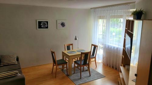 salon ze stołem i krzesłami oraz oknem w obiekcie Mieszkanie w Centrum Ustki w Ustce