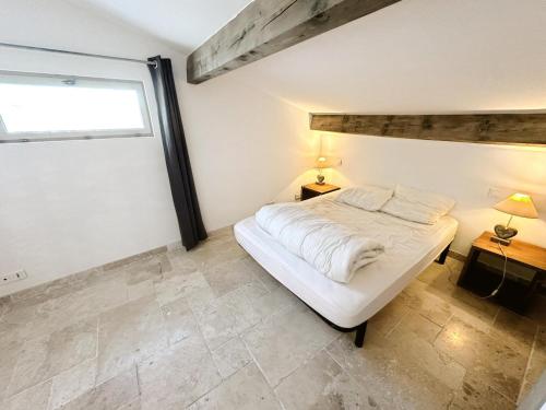 une chambre avec un lit blanc et une fenêtre dans l'établissement maison à la campagne, à Moulès