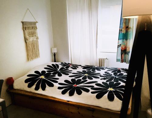 une chambre avec un lit avec une couverture noire et blanche dans l'établissement Chambre ville & campagne, à Nantes