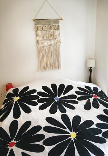 a bed with a black and white bedspread with flowers on it at Chambre ville & campagne in Nantes