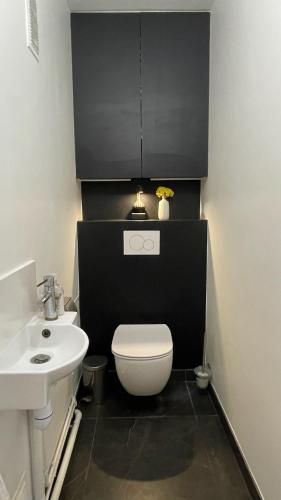 une salle de bain avec des toilettes blanches et un lavabo dans l'établissement Appt 2 Chambres Vue Tour Eiffel, à Paris