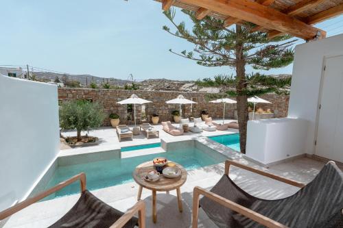 a villa with a swimming pool and a patio at Oliving Mykonos Luxury Suites in Klouvas