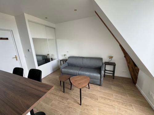 un salon avec un canapé et une table dans l'établissement Studio au calme proche Paris, à Chatou