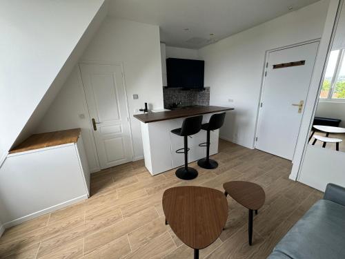 - un salon avec une cuisine dotée d'un comptoir et d'un tabouret dans l'établissement Studio au calme proche Paris, à Chatou