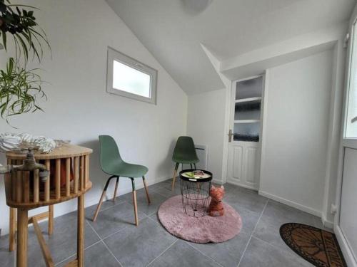 un salon avec une table et deux chaises et un tablecher dans l'établissement Le Renard -maison cosy-, à Salbris