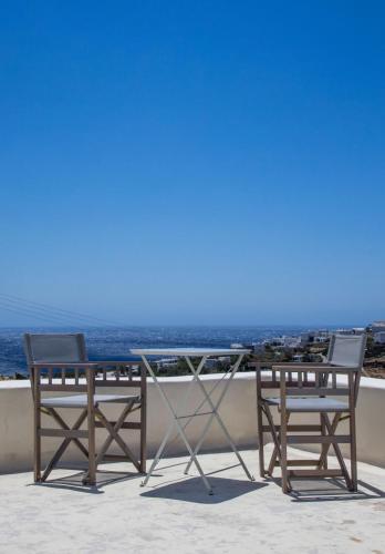 two chairs and a table on a balcony with the ocean at Aster house Agios Sostis in Agios Sostis