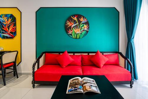 a red couch with red pillows in a living room at Otis Soho Saigon Balcony Apartment in Ho Chi Minh City