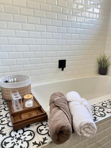 Un baño con bañera con toallas y bandeja. en Sage Serenity Retreat, en Ciudad del Cabo