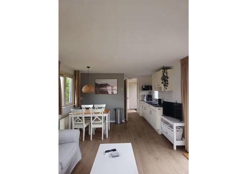 a living room and kitchen with a couch and a table at Chaletparc Krabbenkreek Zeeland - Chalet 110 in Sint Annaland