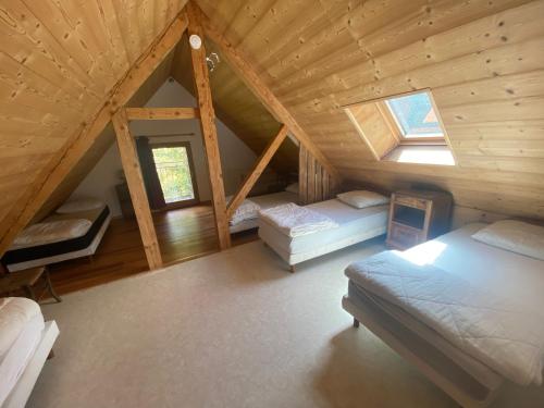 Cette chambre mansardée comprend 2 lits et une fenêtre. dans l'établissement Grand gîte 10-12p à la montagne proche des Ecrins, à Les Achards