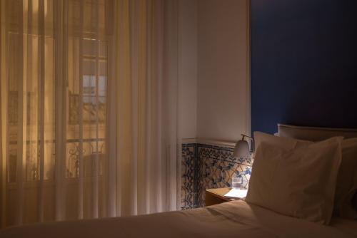una camera con un letto accanto a una finestra di Boutique Chiado Suites a Lisbona