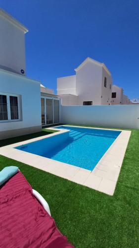a swimming pool in the backyard of a house at Villa Esmeralda in Tías