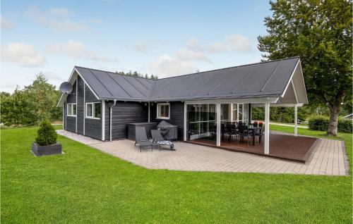 a house with a black roof and a patio at Lovely Home In Hobro With Wifi in Hobro