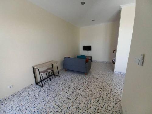 un soggiorno con un divano blu e un tavolo di Guesthouse Jogja Selatan 1 Yogya South-Bantul Casa del Oceano a Gandok
