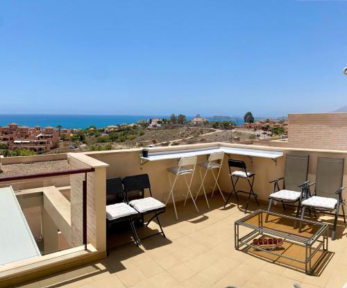 a balcony with chairs and a bar on the roof at Amazing Sea View! in Isla Plana