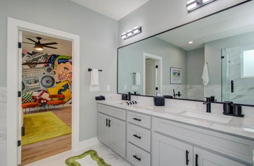 une salle de bain avec deux lavabos et un grand miroir dans l'établissement 3bd-Rooftop Movie Theater-BBQ-Retro Music Theme-Downtown 8mins, à Houston