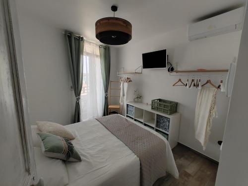 une chambre blanche avec un lit et une fenêtre dans l'établissement bord de mer 