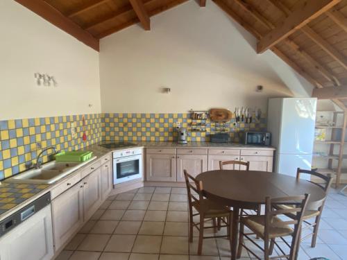La cuisine est équipée d'une table, d'un évier et d'un réfrigérateur. dans l'établissement Grand gîte 10-12p à la montagne proche des Ecrins, à Les Achards