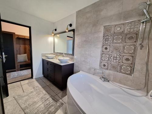 a bathroom with a tub and two sinks and a bath tub at Jazz House in Voroneţ