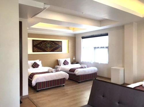 a hotel room with two beds and a window at ViaVia Boutique Hotel - Kathmandu in Kathmandu