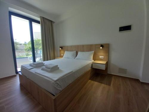 a bedroom with a large bed and a large window at Hotel Ksamili in Ksamil