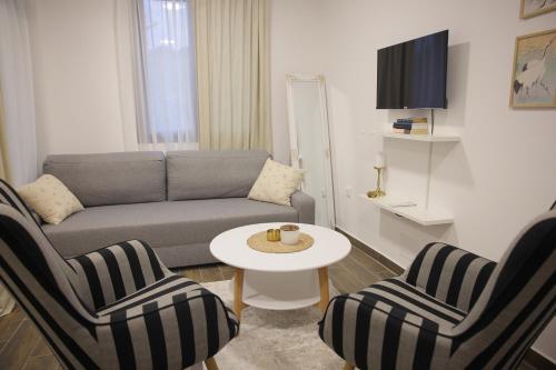 a living room with a couch and two chairs and a table at Adagio Apartmani in Vrnjačka Banja