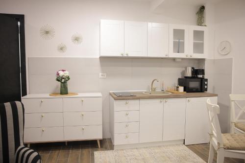 a kitchen with white cabinets and a sink at Adagio Apartmani in Vrnjačka Banja