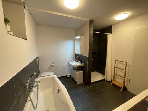 a bathroom with a tub and a toilet and a sink at Ferienwohnung FördeGlück an der Kieler Förde in Mönkeberg