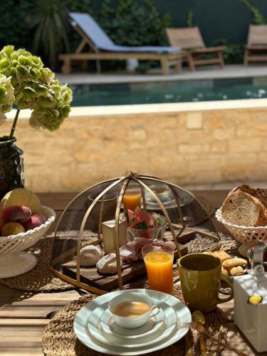 a breakfast table with a tray of food and orange juice at Le Numéro 10 in Bernis