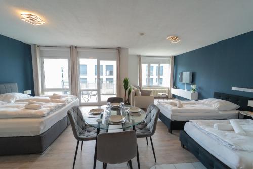 a hotel room with two beds and a table and chairs at RANGE - Apartments - Küche - WLAN - Netflix - 1-7 Personen in Fellbach
