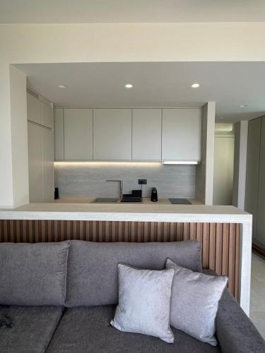 a living room with a couch in front of a kitchen at Palms and Spas Villas Retreat in Mesongi