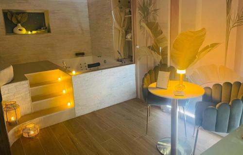 a room with a table and a bathroom with a tub at Moments Loft & Spa Paris in Montesson