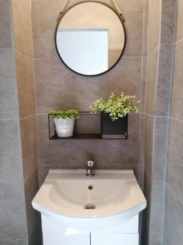 a bathroom with a white sink and a mirror at Apartman ClaRa in Štúrovo