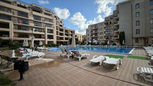 un patio con piscina, sillas y edificios en One bedroom Apartment, en Sunny Beach