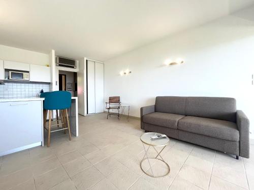 un salon avec un canapé et une cuisine dans l'établissement ARIA MARINA studio Route des SANGUINAIRES plage à 50M PARKING gratuit 2adultes avec 1enfant, à Ajaccio