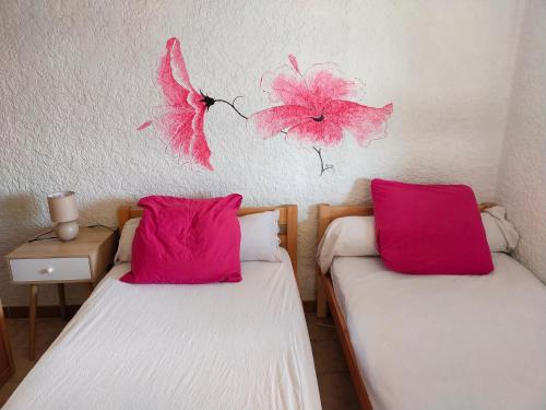 - 2 lits dans une chambre avec des fleurs roses sur le mur dans l'établissement Gîte Canoé Piscine chauffée et Spa en Ardèche Méridionale, à Ruoms