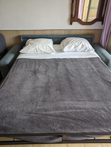 un lit avec deux oreillers dessus dans une chambre dans l'établissement Studio Calme Dernier Etage, à Antibes