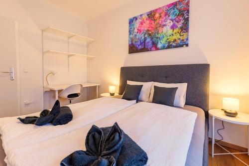 a bedroom with a large white bed with a painting above it at Flataid Cityapartment Stadlgasse - Grießplatz in Graz