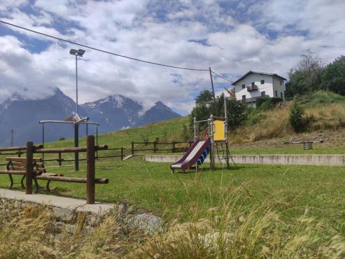 a park with a playground with mountains in the background at Appartamento Ville sur Nus in Quart